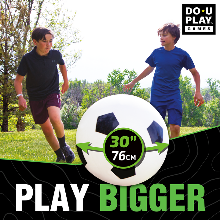 Kids running and chasing jumbo soccer ball at park or playground