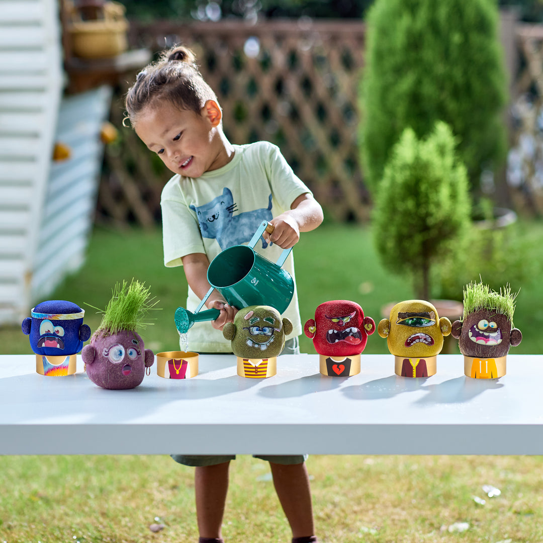 Child playing with toy plants and a watering can outdoors