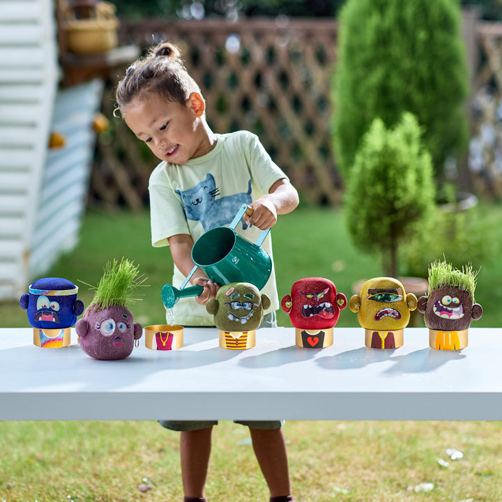 Child playing with toy plants and a watering can outdoors